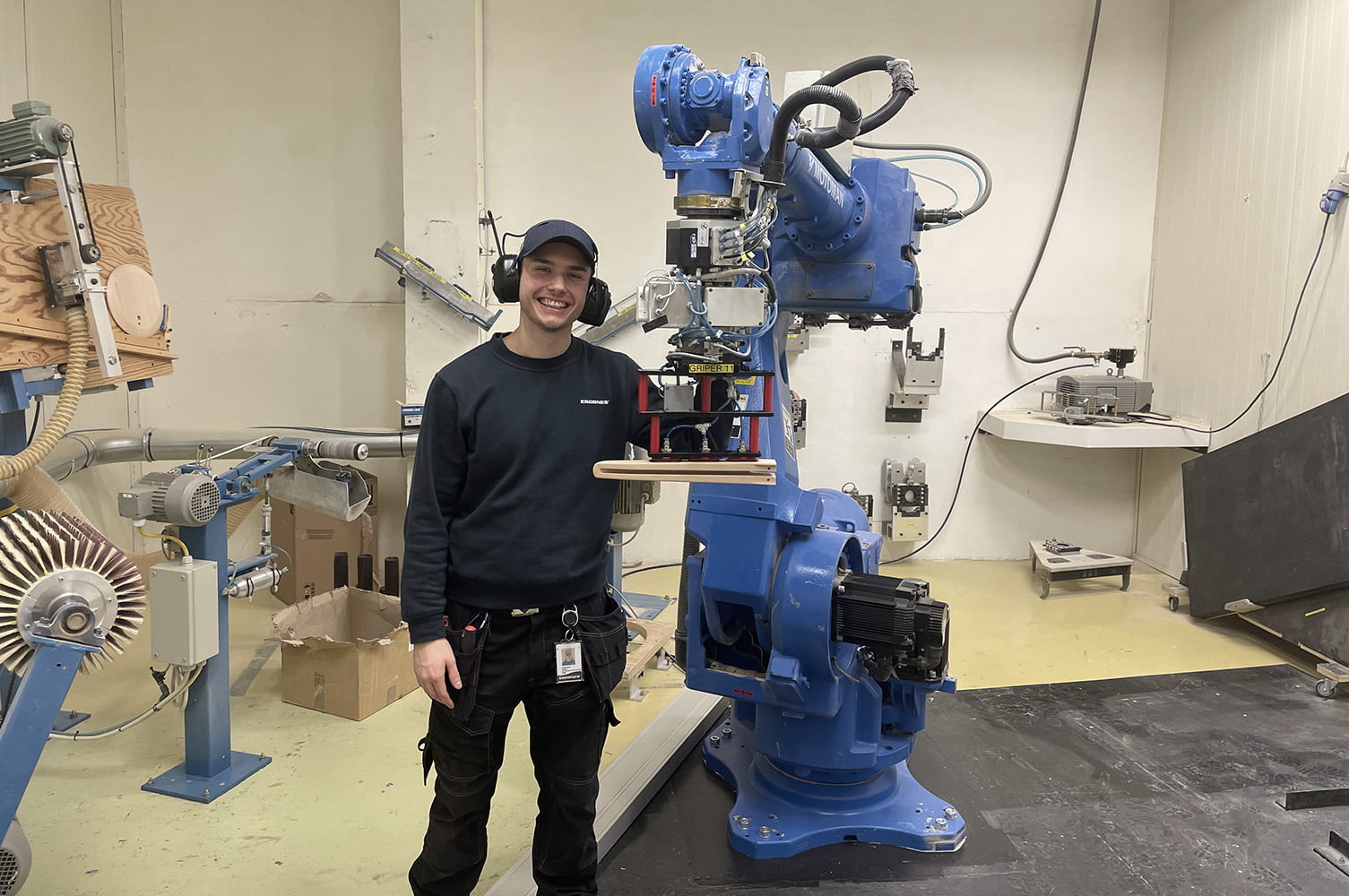 A student standing by a robot
