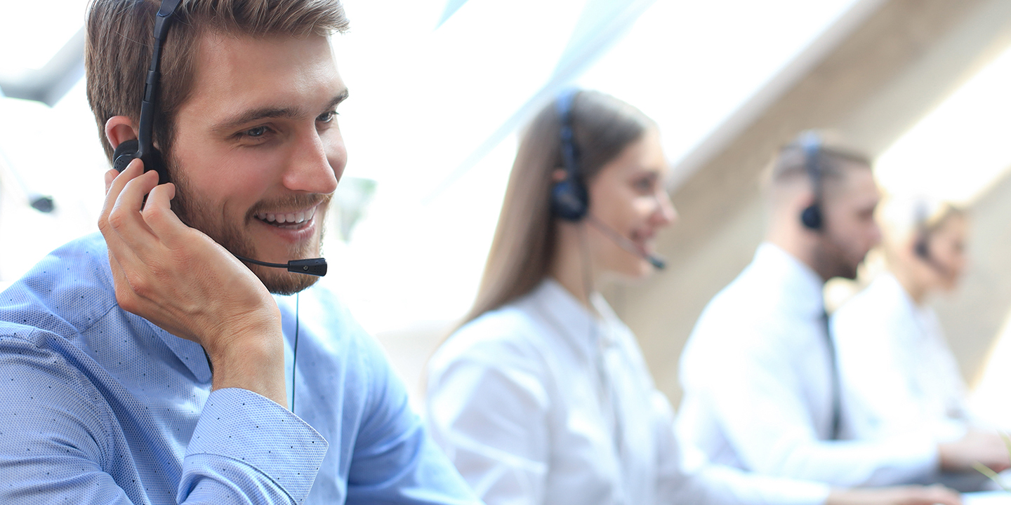 Four people inn call center talking to customer 