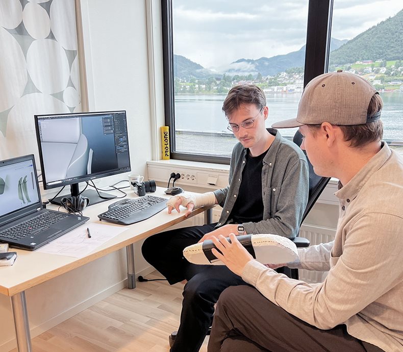 Two Design interns discussing in front of computer
